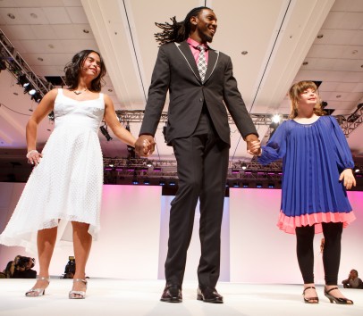 The Denver Nuggets' Kenneth Faried escorts Kristina Sisneros and Katie Smith down the runway at the Be Beautiful Be Yourself Fashion Show